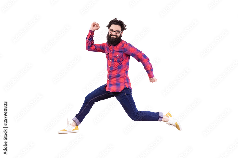 Full length portrait of running and jumping bearded hipster, happy smiling man isolated on white background