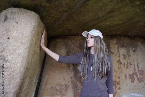 Girl touching ancient megalithic stone dolmen