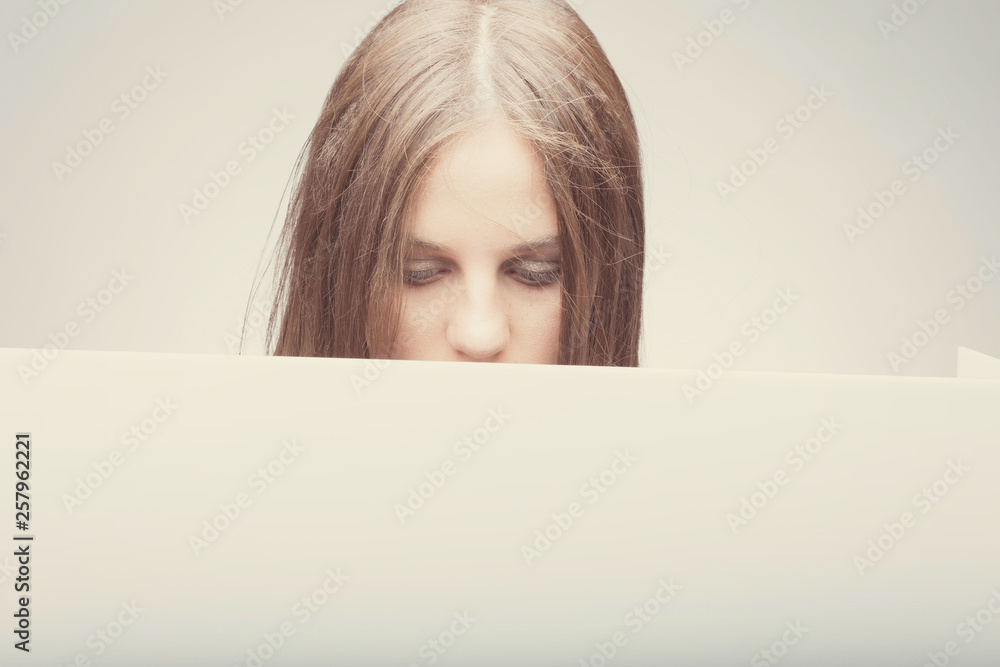 Fashion pretty girl holding white board with place for text. Surprised girl looking serious Fashion pretty girl holding white board with place for text. Surprised girl looking serious