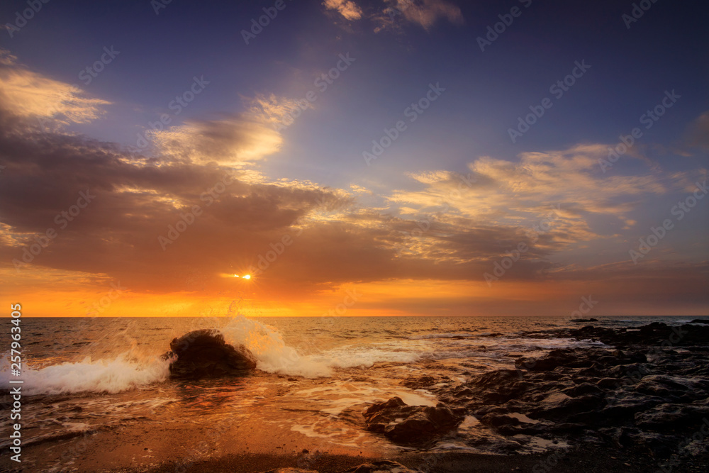 Sunrise or sunset in Fuerteventura by the sea. Beautiful beach photo in Canary Islands Spain. Counter-shot in the morning with great clouds