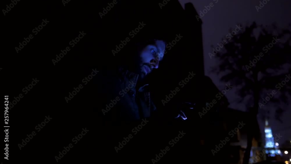 Bearded brutal man with mobile phone at dark night street Bearded brutal man with mobile phone at dark night street