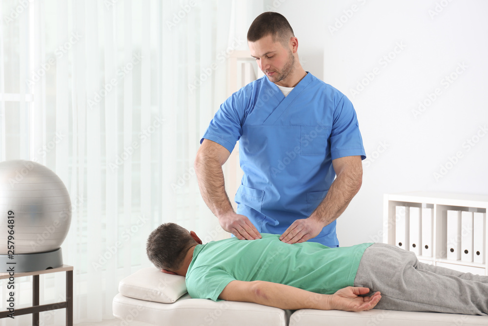 Fototapeta premium Doctor working with patient in hospital. Rehabilitation massage