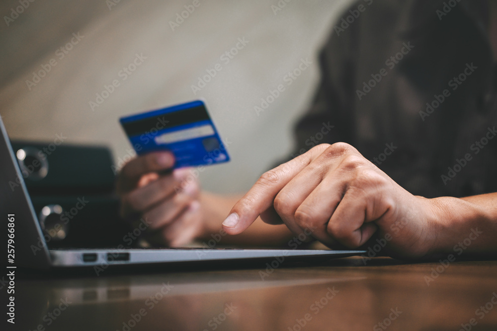 Businessman holding credit card and typing on laptop for online shopping and payment makes a purchase on the Internet, Online payment, Business financial and technology