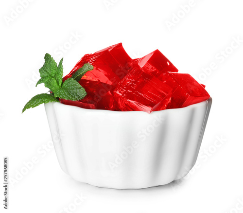 Bowl with red jelly cubes on white background photo