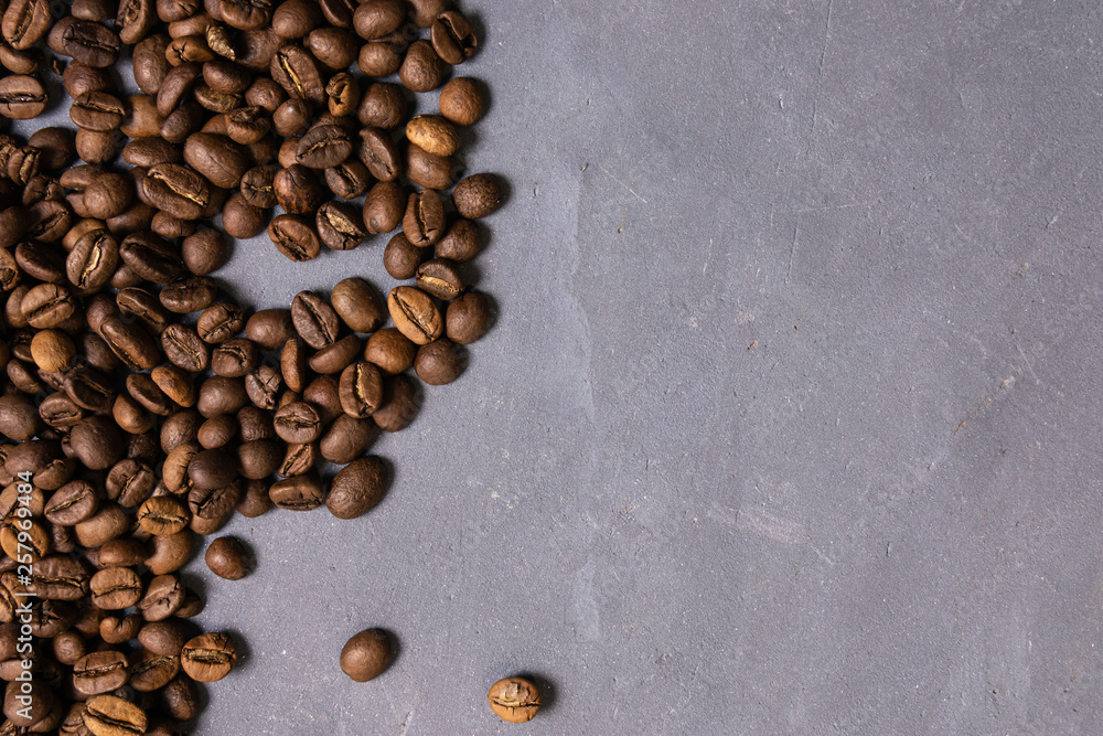 Roasted coffee beans in bulk on a gray concrete background. dark cofee roasted grain flavor aroma cafe, natural coffe shop background, top view from above, copy space Roasted coffee beans in bulk on a gray concrete background. dark cofee roasted grain flavor aroma cafe, natural coffe shop background, top view from above, copy space
