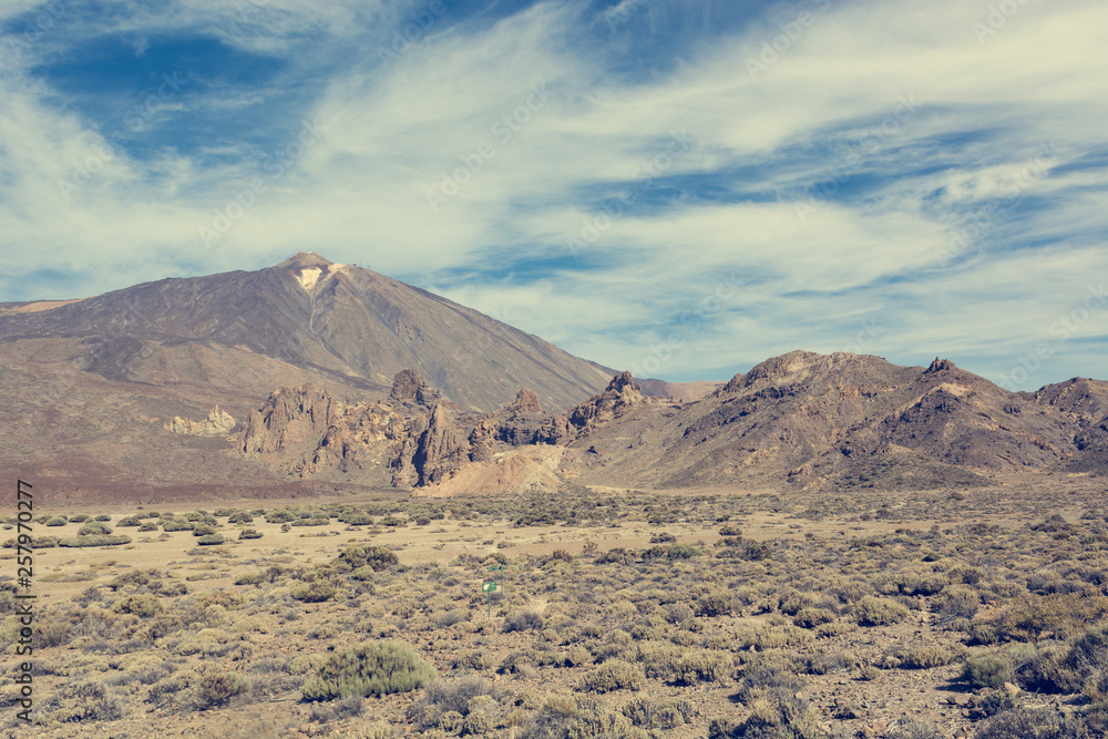 Panoramic view of spectacular volcanic landscape with cone raising high above the gorund.