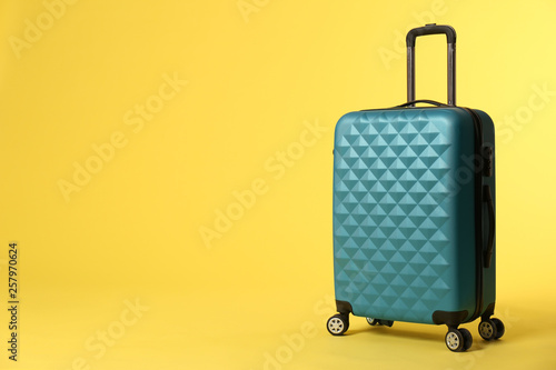 Stylish suitcase on color background. Space for text Fototapeta