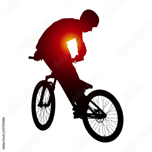 Silhouette of biker doing whip on mtb bike. 