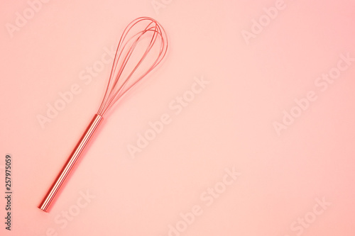 whisk on pink pastel background. Top view, minimalism. toned Living coral