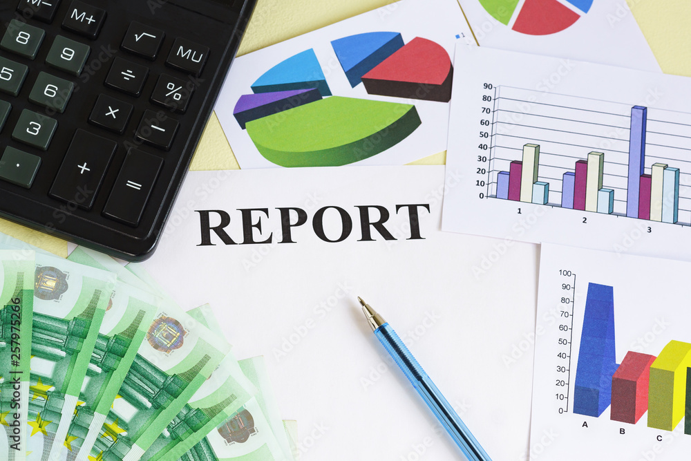 Preparation of the financial report. Money, calculator, pen, color charts and diagrams on the table Preparation of the financial report. Money, calculator, pen, color charts and diagrams on the table