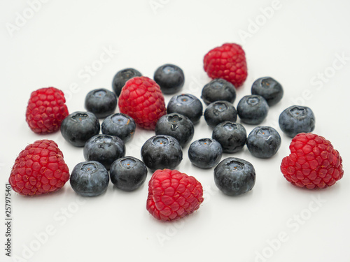 Blueberries and raspberries on white background