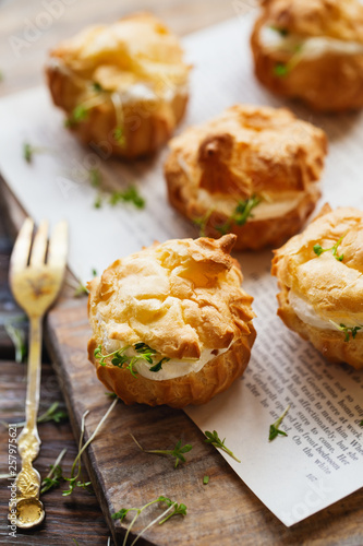 Spicy profiteroles with cream cheese decorated with cress salad