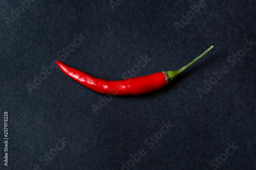pod of red chili pepper on black background