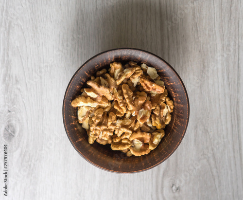 Healthy food for background image close up walnuts. Nuts texture on white grey table top view on the cup plate