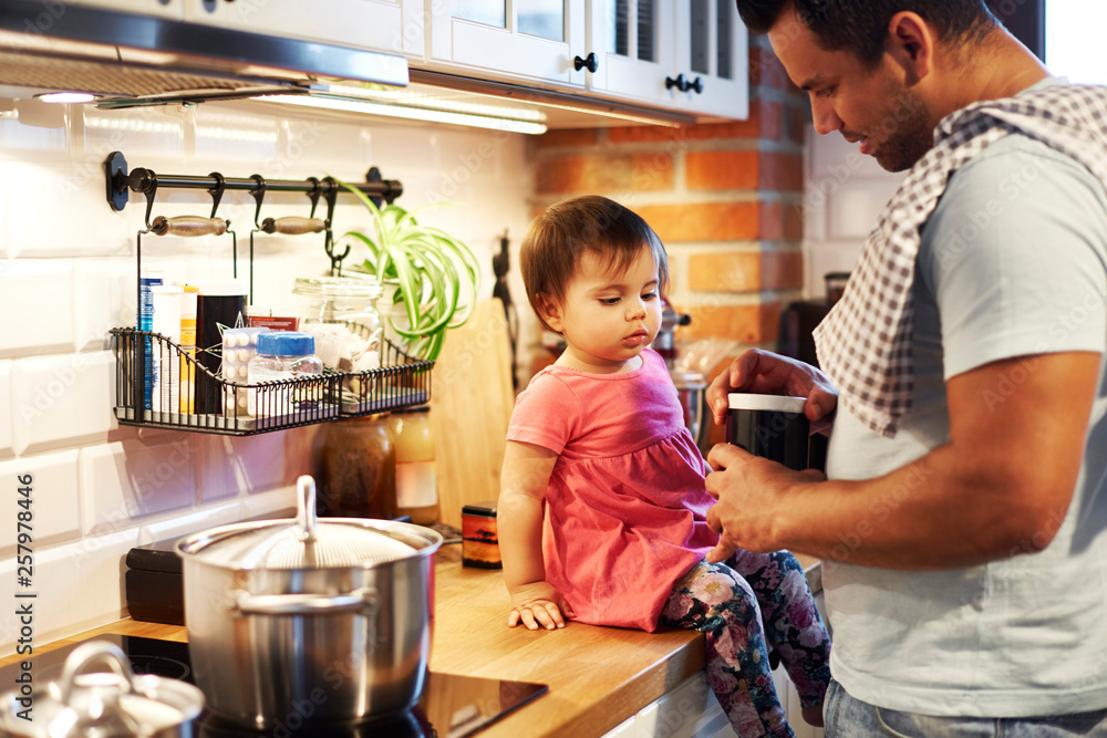 Father and baby girl cooking together in kitchen at home Father and baby girl cooking together in kitchen at home