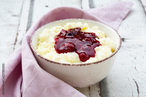 Bowl of rice pudding with cherry and berry groats