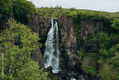 Waterfall in the stones. waterfall in a green forest. waterfall among the green trees.