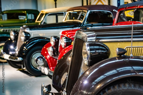 Display of colorful classic cars parked next to each other in an exhibit hall