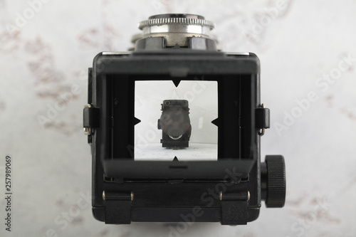 The old medium format film TLR camera on white cement background. Top view of the camera viewfinder.