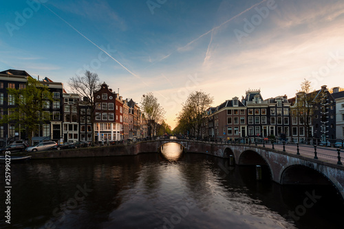 Bild auf Leinwand City view of Amsterdam, the Netherlands with Amstel river during sunset