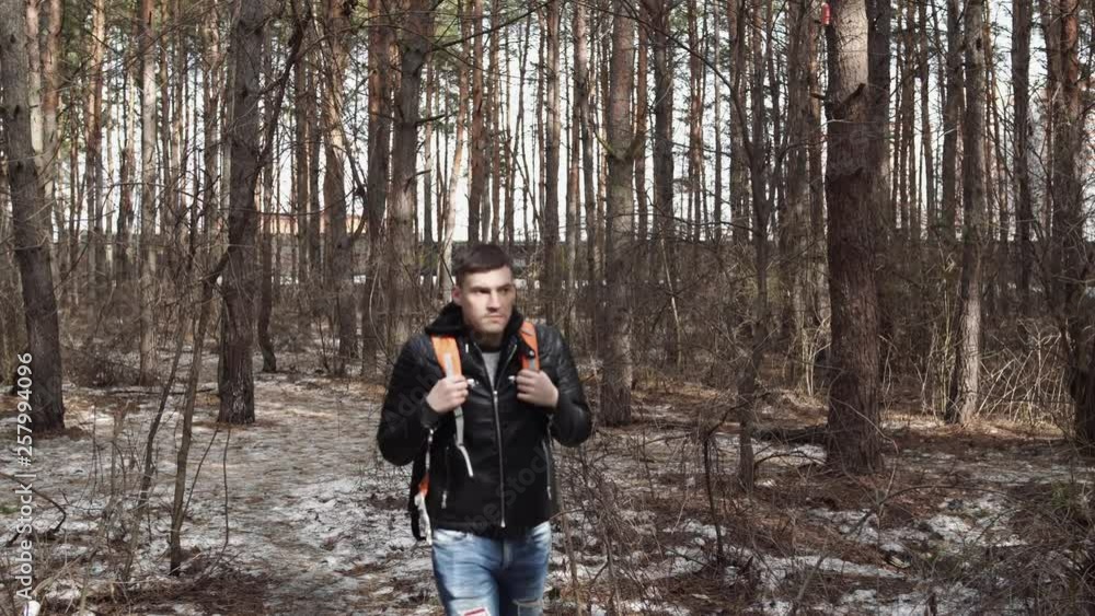 Traveler Man with backpack hiking Travel Lifestyle concept. The traveler goes through the forest Traveler Man with backpack hiking Travel Lifestyle concept. The traveler goes through the forest