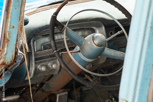 Old rusty and damaged antique car wreck in very poor condition on house yard.