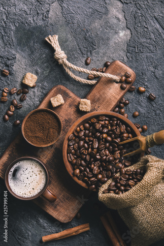 Black fried coffee beans on dark textured background