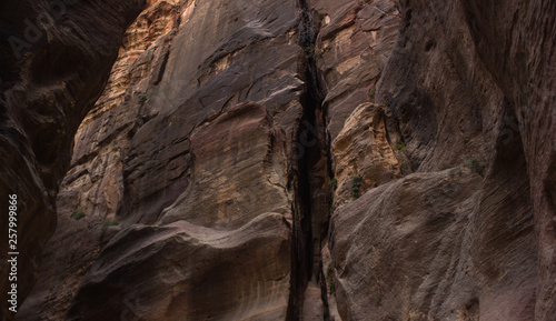 twilight darkness between steep rocky walls on wild canyon dry desert Middle East environment foreshortening from below