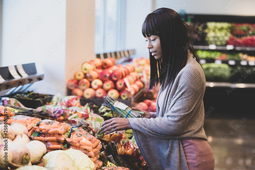 Φωτογραφία African American woman shopping for produce in grocery store