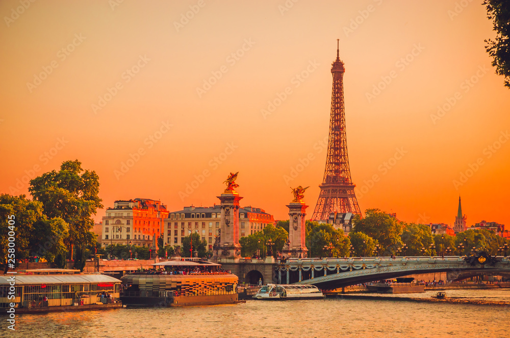 Sunset view of Eiffel Tower, Alexander III Bridge and river Seine in Paris, France.