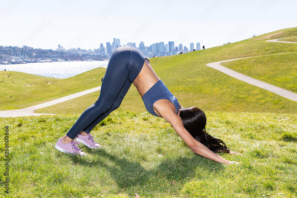 an elegant girl in black leggings and a sports bra is doing yoga -  Playground