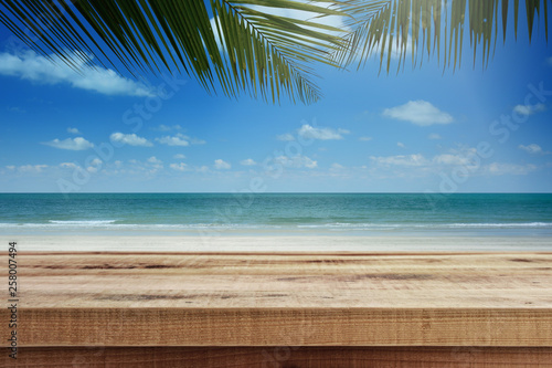 Tropical beach background with palm tree and empty wooden, Summer. © Ubonwan