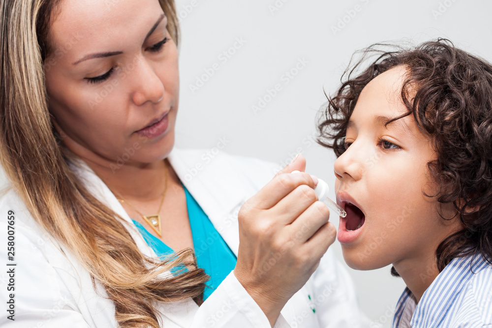 Doctor giving a child homeopathic medicine Doctor giving a child homeopathic medicine