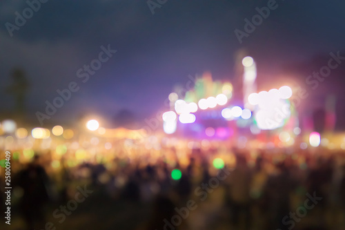 Blurred people at outdoor concert stage.