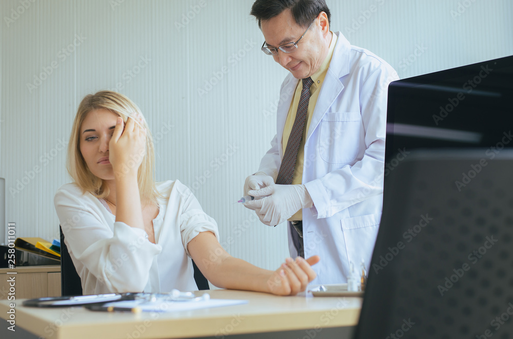 Obraz premium Doctor giving vaccine to frightened patient woman with injection or syringe in hospital