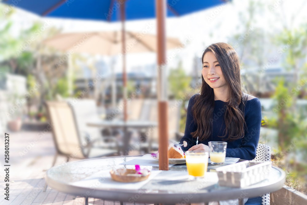 オープンテラスカフェで余暇を楽しみむ女性 オープンテラスカフェで余暇を楽しみむ女性