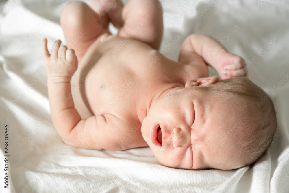 Newborn naked baby crying on the bed Newborn naked baby crying on the bed