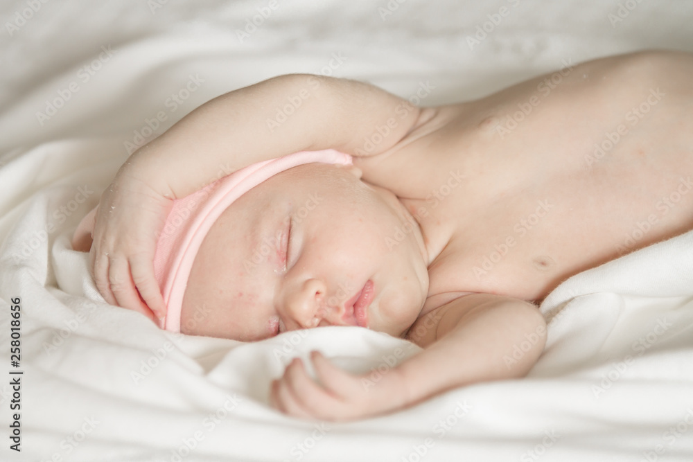 Close up of a sleeping naked newborn baby girl on a white blanket Close up of a sleeping naked newborn baby girl on a white blanket