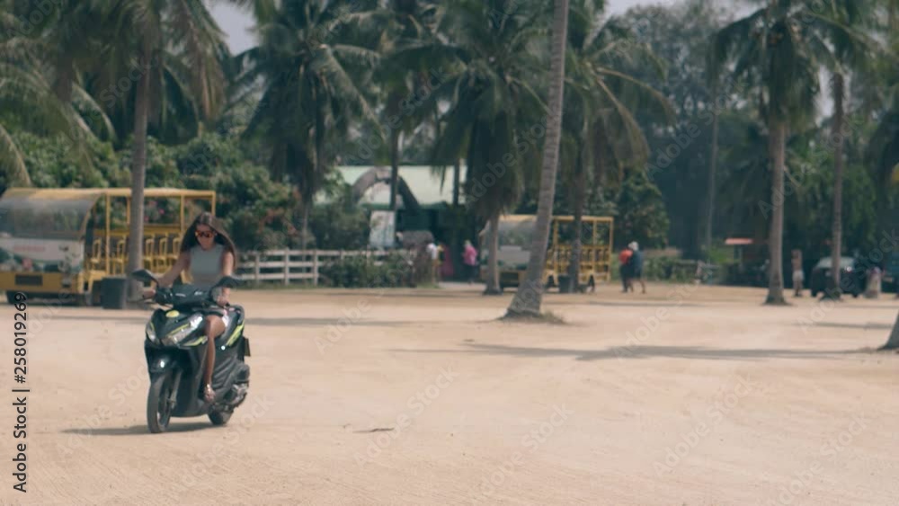 beautiful girl with dark straight hair rides slowly cool black motorcycle on square among tropical palms tourist cars beautiful girl with dark straight hair rides slowly cool black motorcycle on square among tropical palms tourist cars