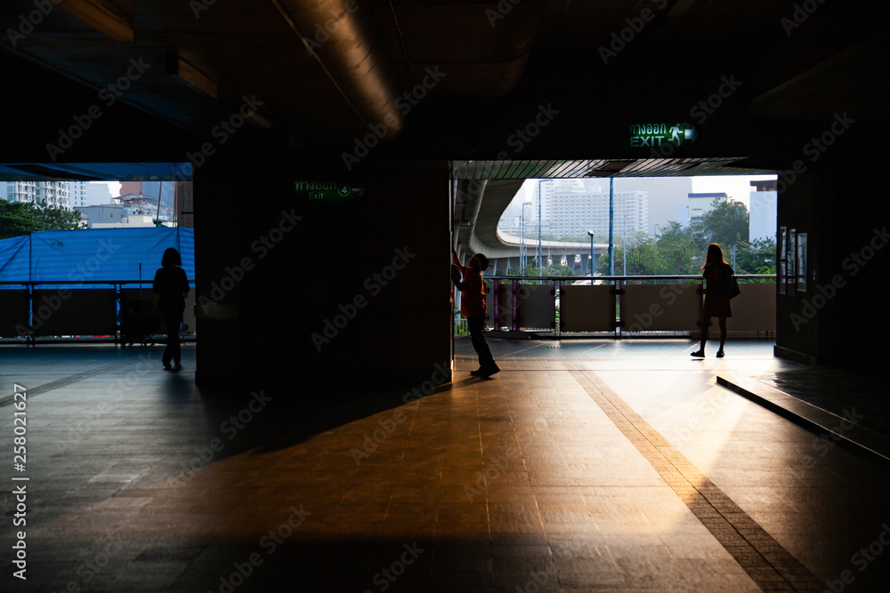commuter silhouettes in a station in early morning