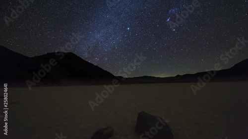 Inclined motion nighttime time lapse of the milky way over moving rocks on the Racetrack Playa