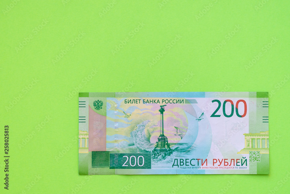 Two hundred ruble bill on a yellow paper background. Two hundred ruble bill on a yellow paper background.