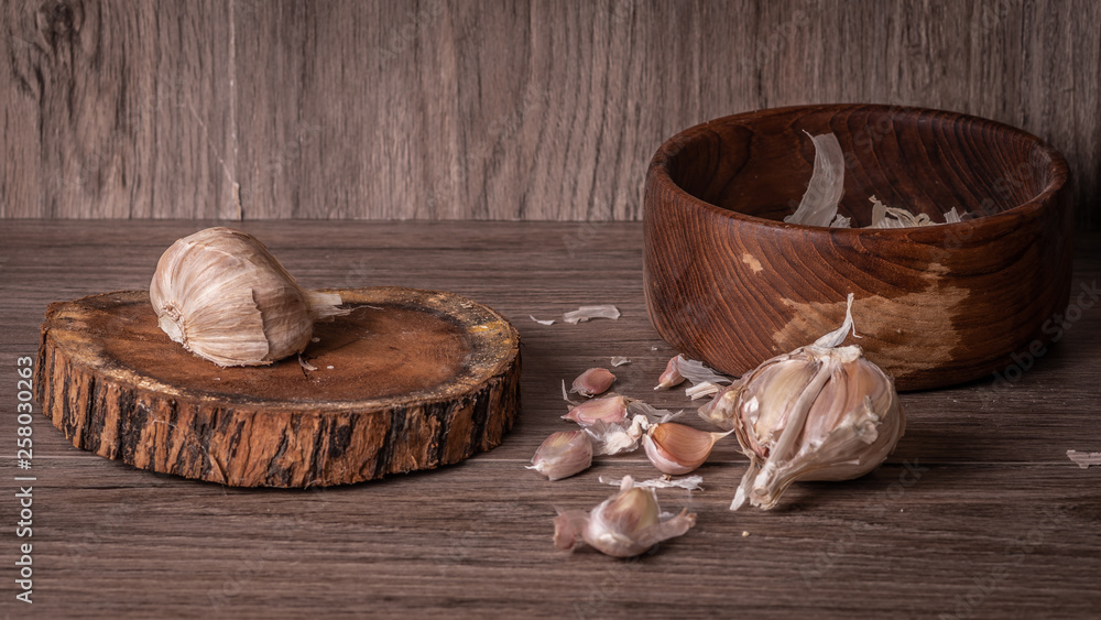 Garlic in a bowl on wooden table Garlic in a bowl on wooden table