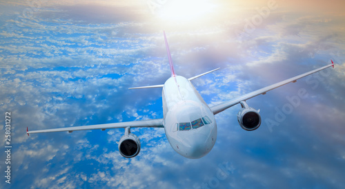 White Passenger airplane in the clouds at sunset - Travel by air transport