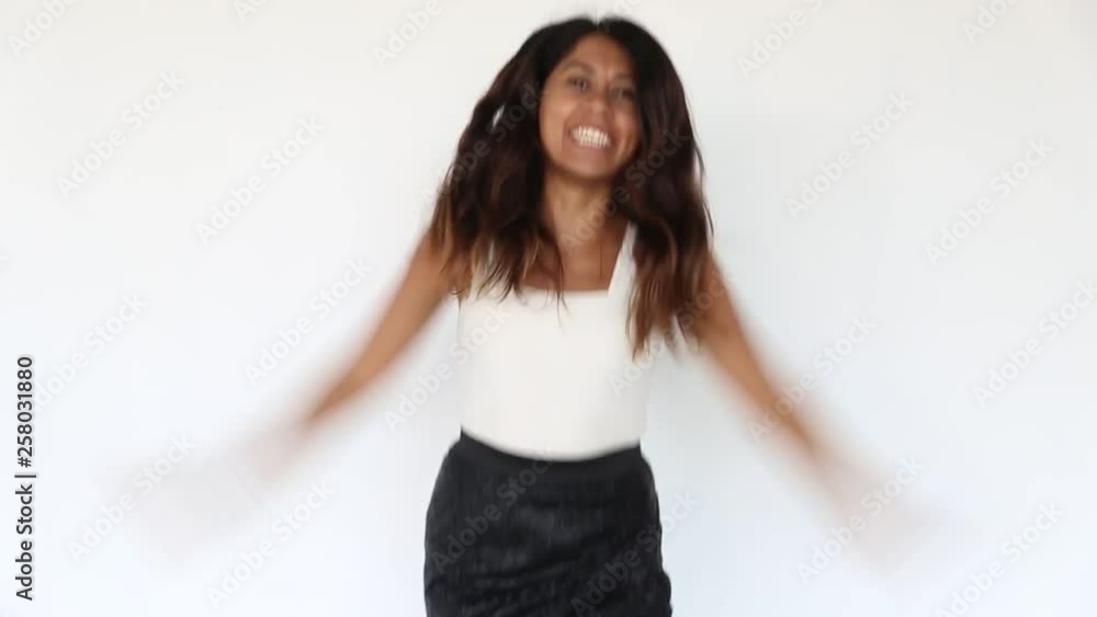 Pretty young latin woman is dancing and having fun standing on white background. Pretty young latin woman is dancing and having fun standing on white background.