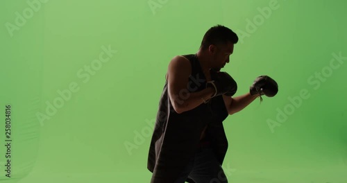 Old school boxer ready to fight throwing punches, jabs, hooks, uppercuts sport boxing against green screen slow motion  photo