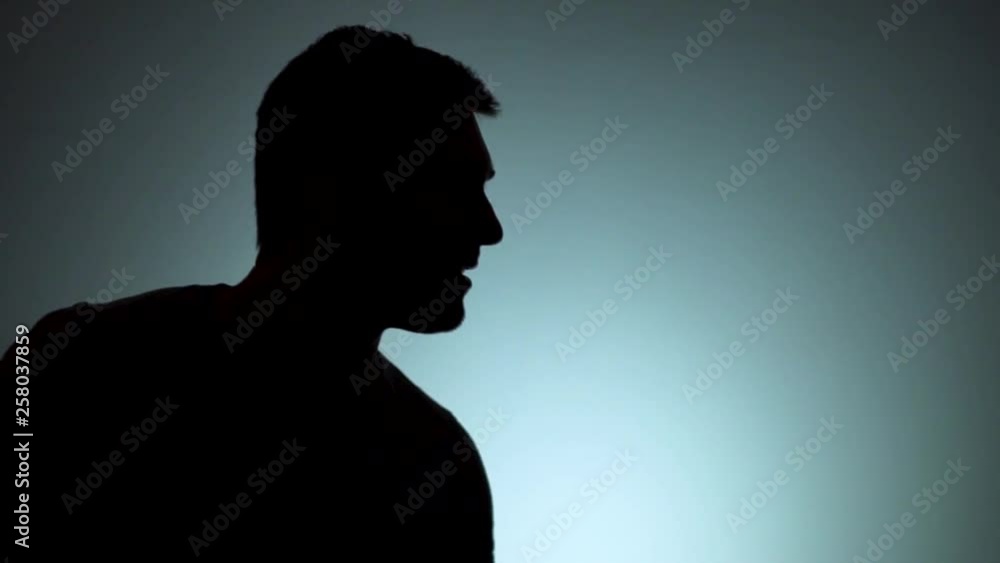Silhouette of a man. The shadow of a man on a light background. A man in a rage, a man angry, pointing with his index finger. Emotions, negative, rage. Slow motion Silhouette of a man. The shadow of a man on a light background. A man in a rage, a man angry, pointing with his index finger. Emotions, negative, rage. Slow motion