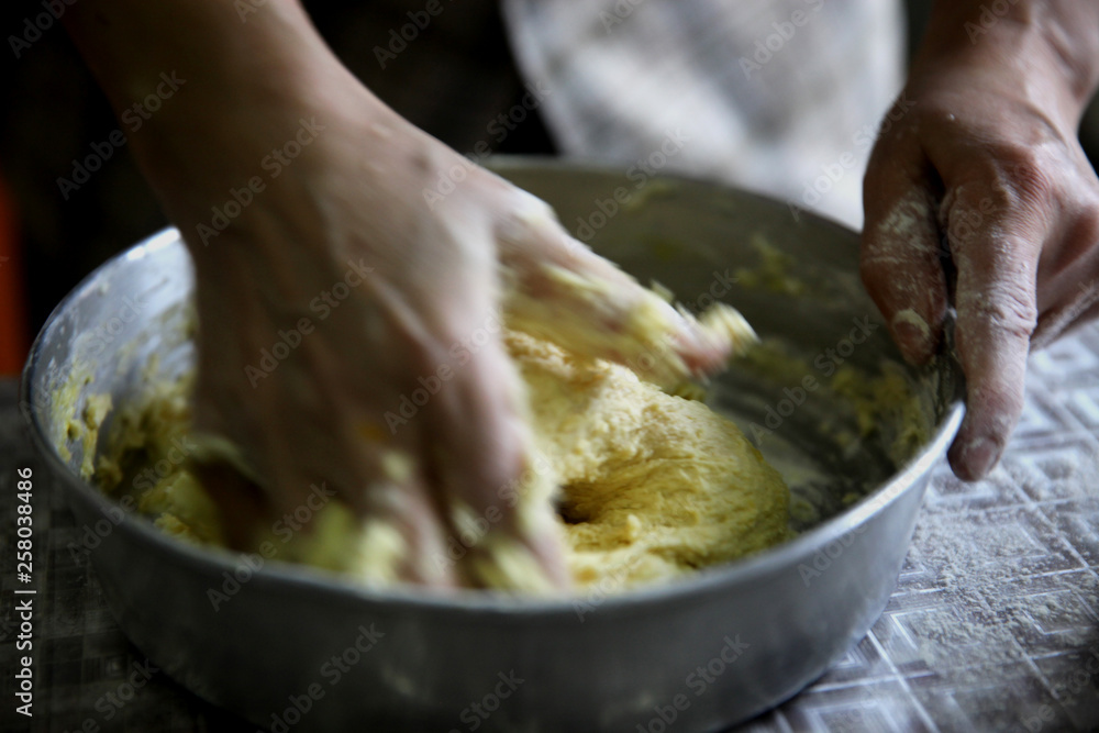 Fototapeta premium Making dough by female hands at bakery