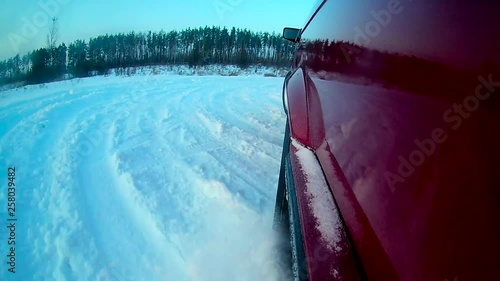 The camera is on the left wing of the car, which drifts in the snow in winter