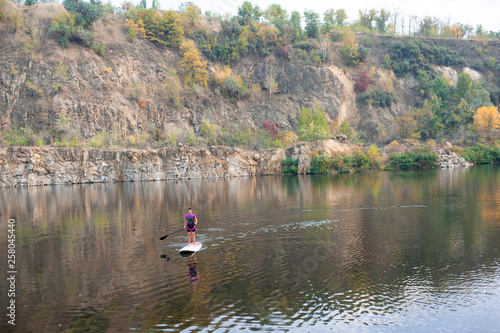 Sports woman paddleboarding on the mountain lake